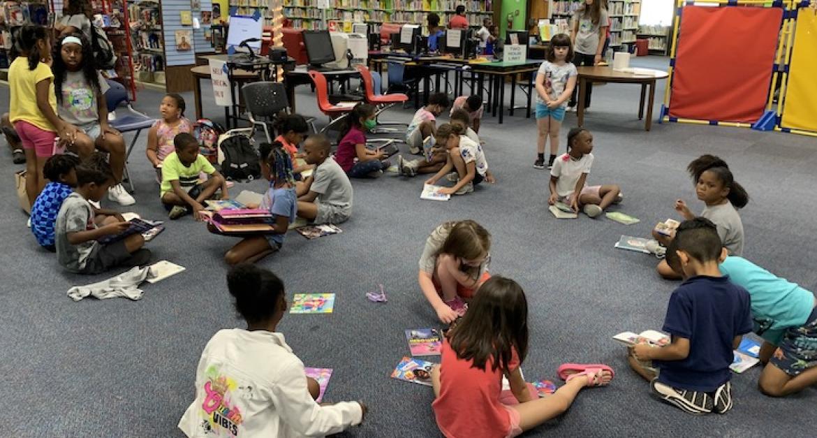 Small children playing reading in small groups